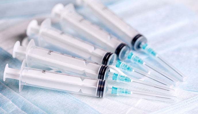 Hypodermic syringes and needles on protective mask