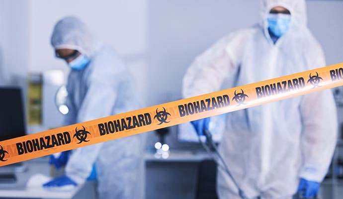 Biohazard caution tape with forensic workers