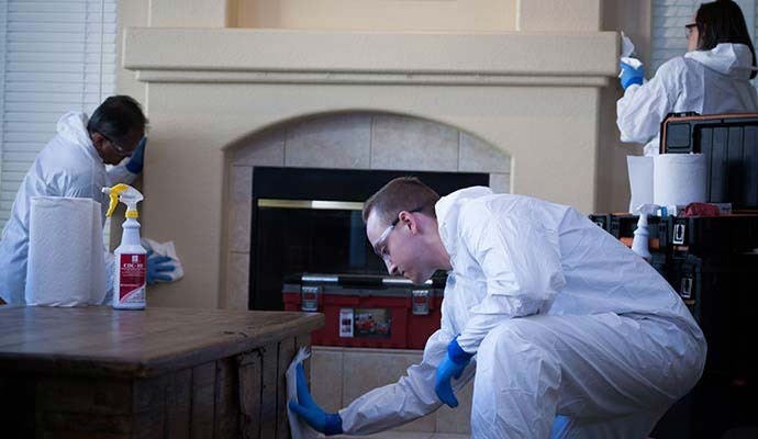 Biohazard cleanup crew sanitizing living room