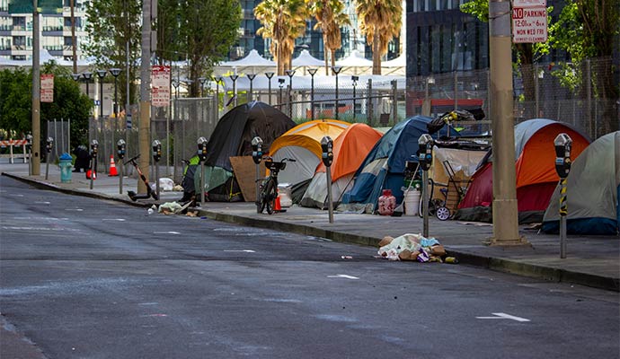 A line of temporary encampment positioned along a sidewalk