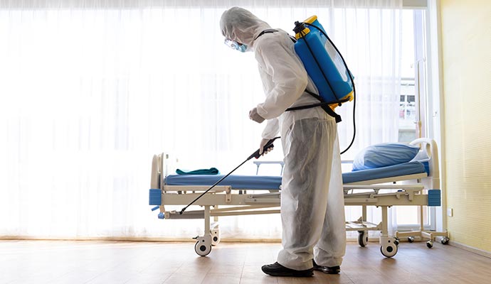 A professional spraying on hospital room floor