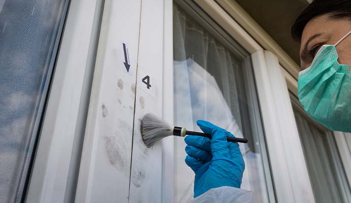 An expert cleaning fingerprint dust from a window frame
