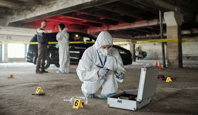 Forensic investigator collecting evidence at crime scene