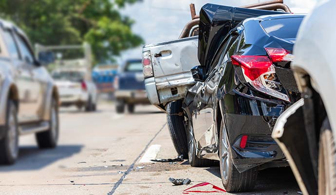 Black sedan rear-ended into a pickup truck after a road traffic accident