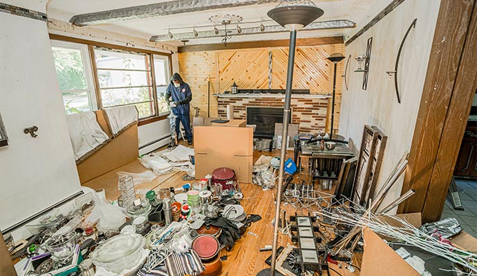 A professional cleaning a hoarding-cluttered room